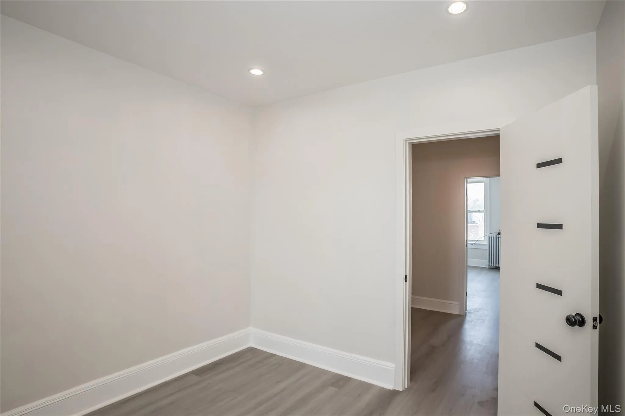 Unfurnished room with baseboards, wood finished floors, and recessed lighting Unfurnished room with baseboards, wood finished floors, and recessed lighting