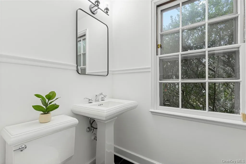 Bathroom with toilet, a sink, and baseboards Bathroom with toilet, a sink, and baseboards