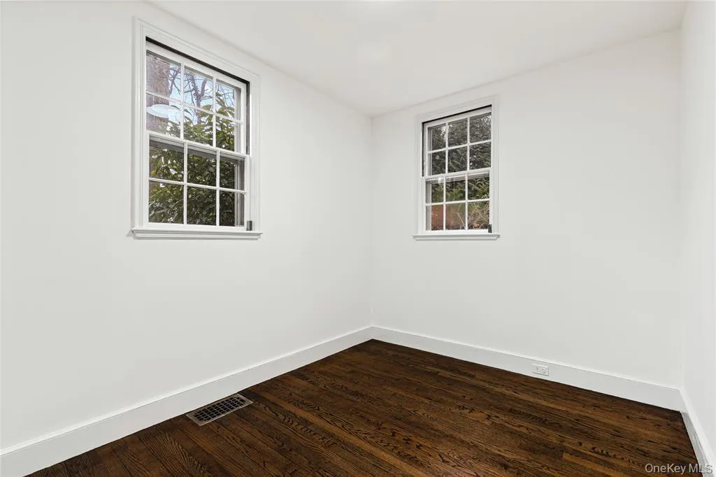 Spare room with baseboards, and dark wood finished floors Spare room with baseboards, and dark wood finished floors