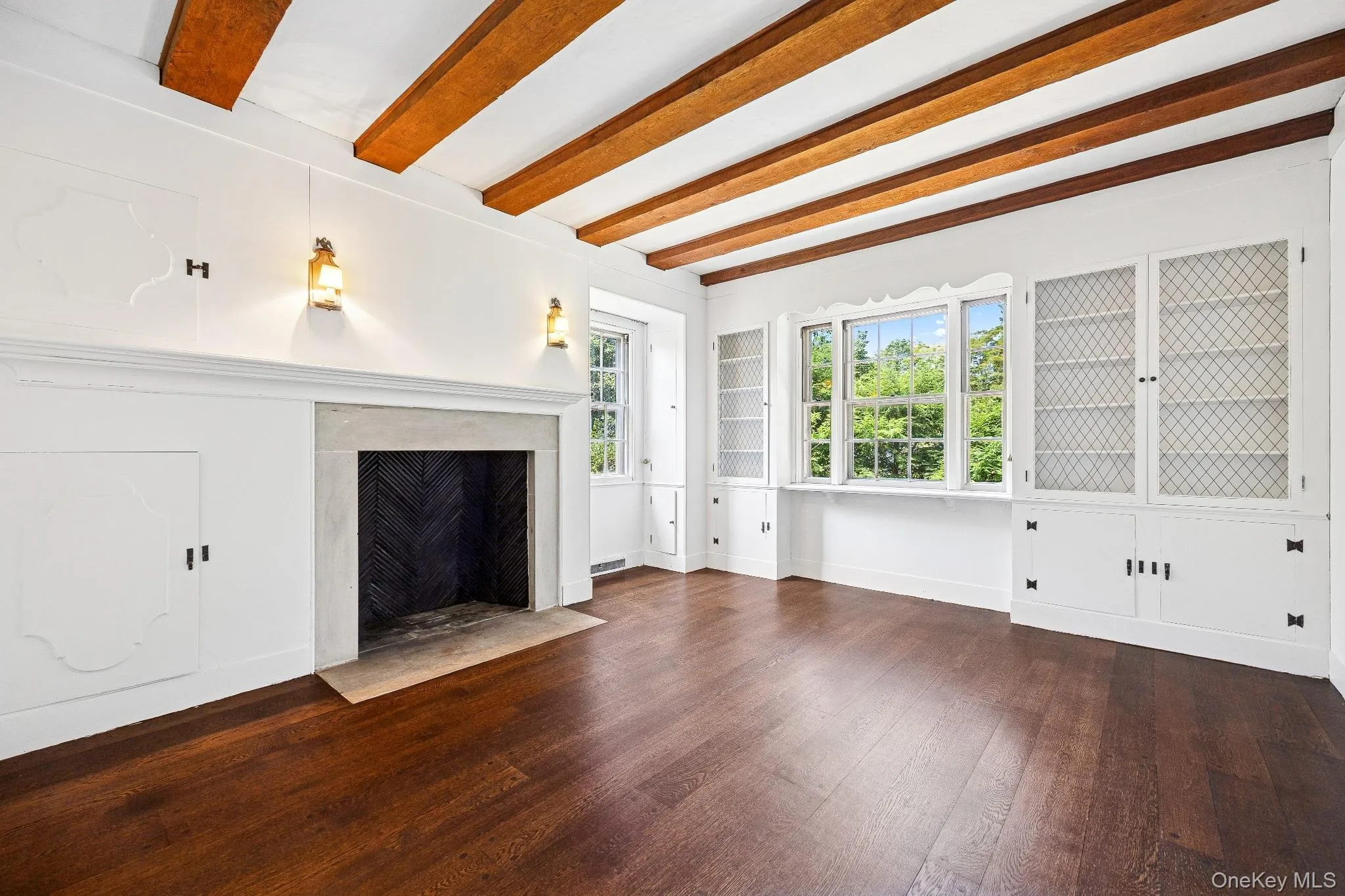 Unfurnished living room with beamed ceiling, a high end fireplace, and wood finished floors Unfurnished living room with beamed ceiling, a high end fireplace, and wood finished floors