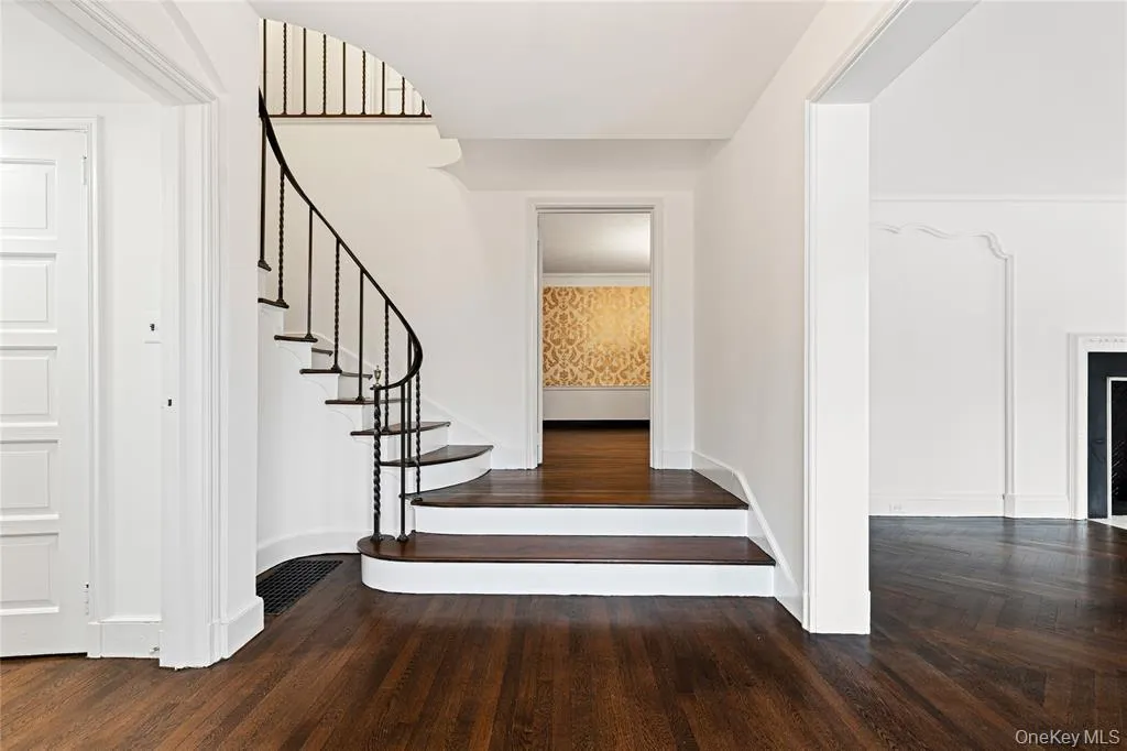 Stairs with wood finished floors, visible vents, and baseboards Stairs with wood finished floors, visible vents, and baseboards