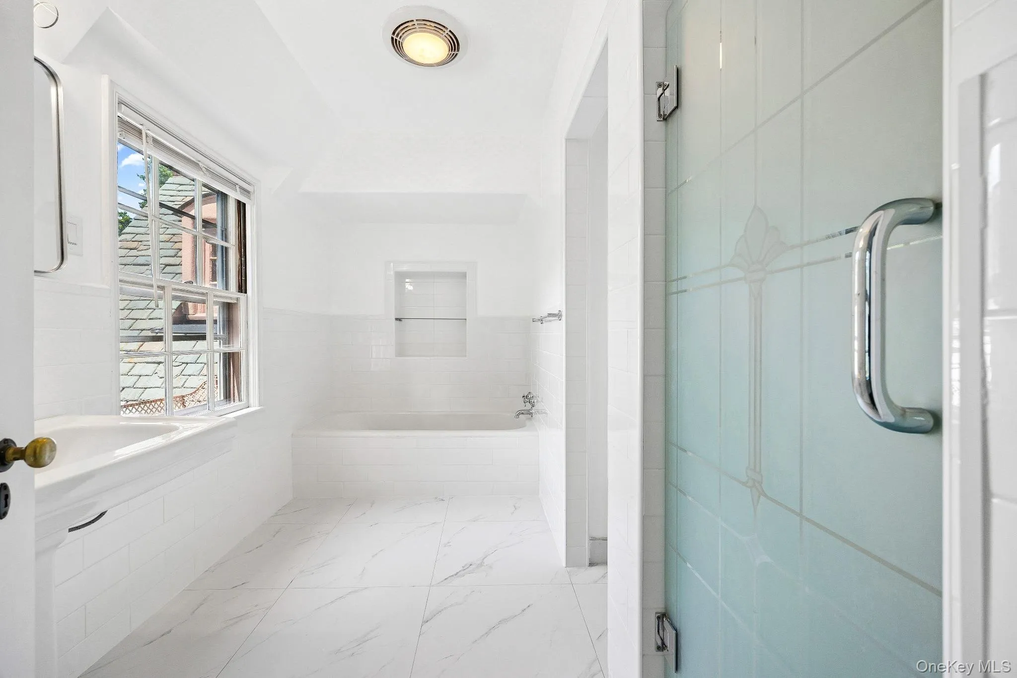 Bathroom with a bath and marble finish flooring Bathroom with a bath and marble finish flooring