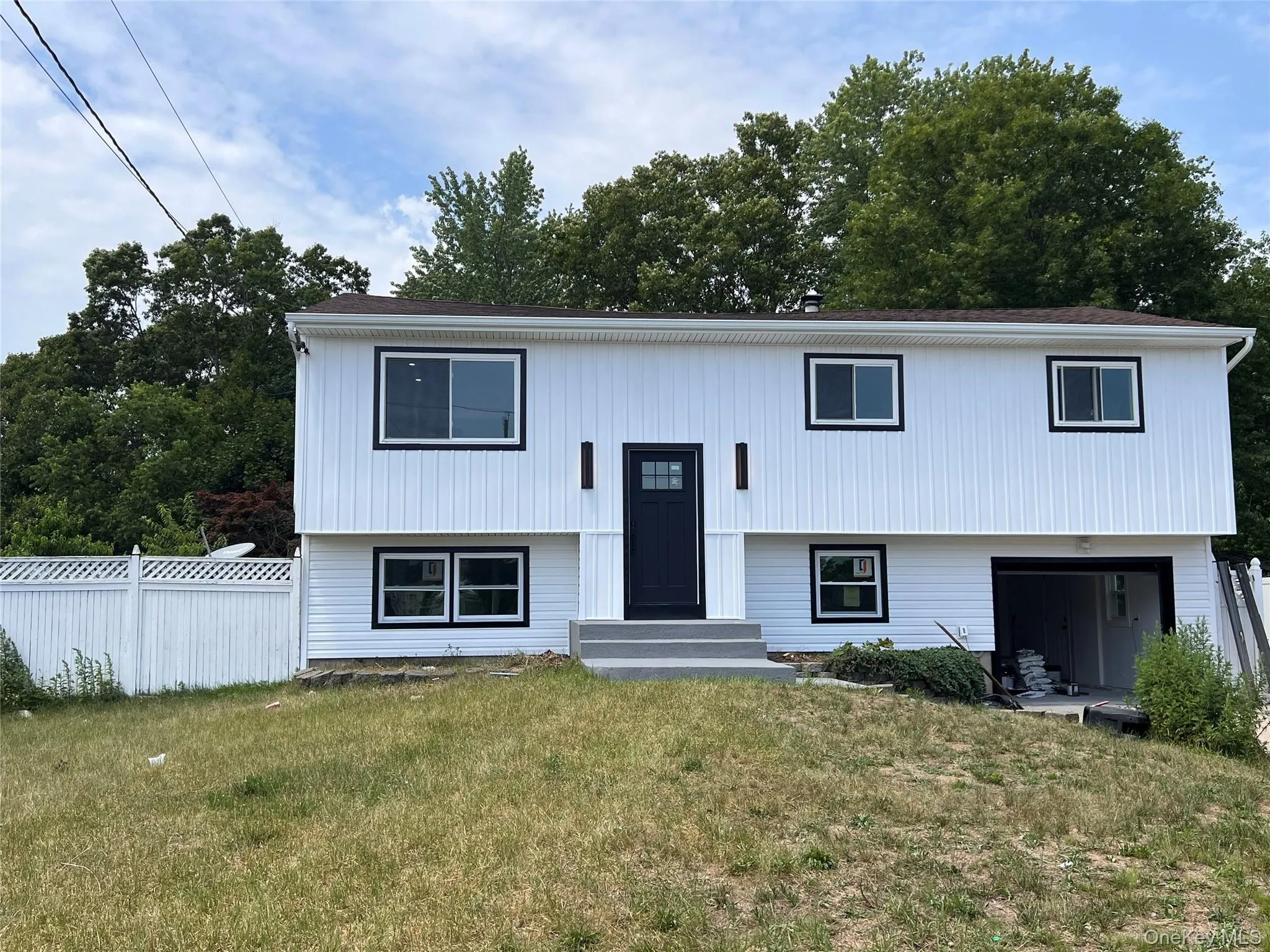 residence featuring white vertical siding with dark trim accents residence featuring white vertical siding with dark trim accents