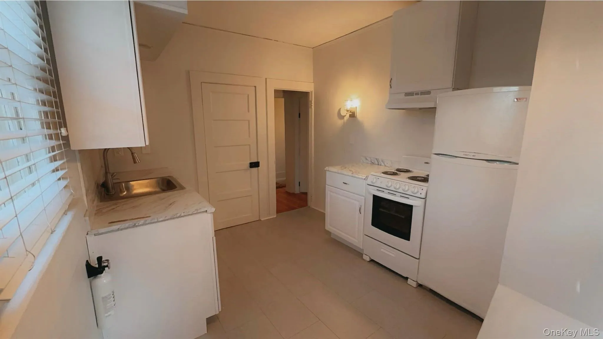 Kitchen featuring white cabinetry, sink, extractor fan, and white appliances Kitchen featuring white cabinetry, sink, extractor fan, and white appliances