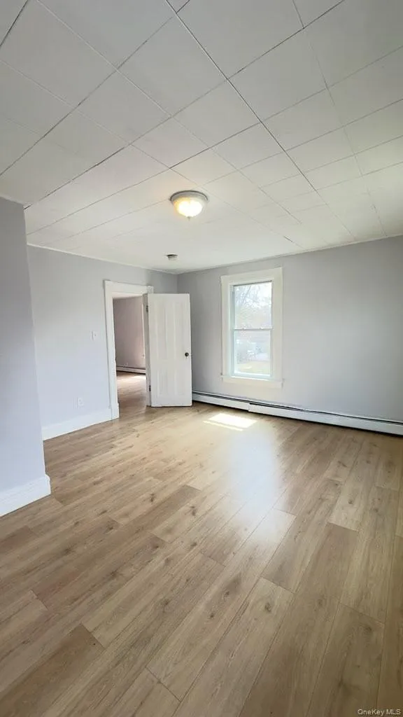 Empty room featuring light wood-style flooring and baseboards Empty room featuring light wood-style flooring and baseboards