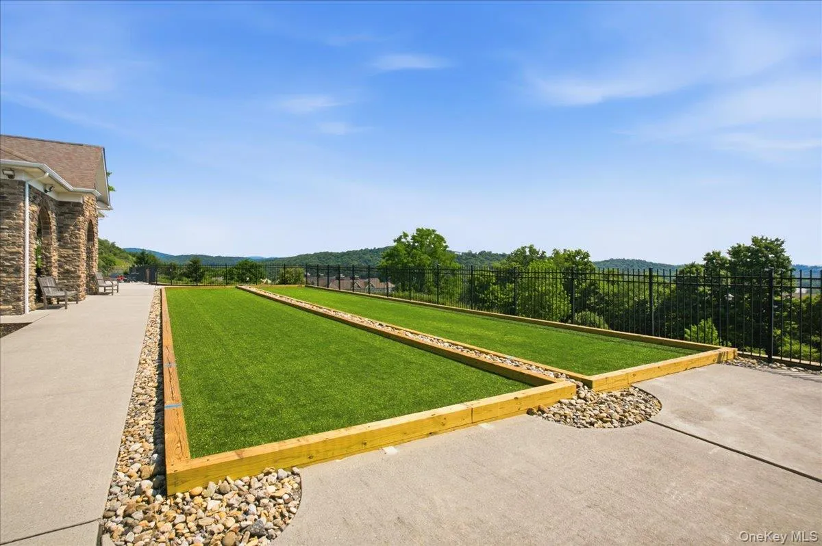 Manicured lawns framed by wood timbers, concrete hardscaping, and decorative stone accents Manicured lawns framed by wood timbers, concrete hardscaping, and decorative stone accents