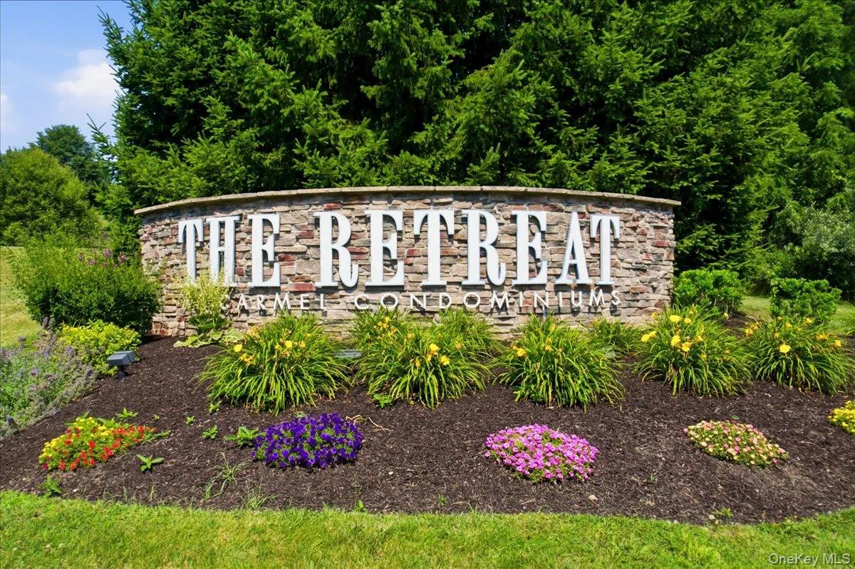 Stone-clad monument sign featuring dimensional lettering, surrounded by varied ornamental shrubs and colorful perennial plantings Stone-clad monument sign featuring dimensional lettering, surrounded by varied ornamental shrubs and colorful perennial plantings