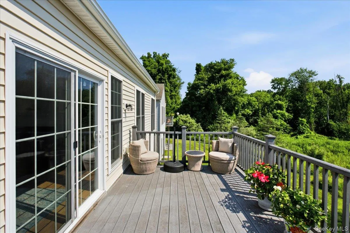 Outdoor deck featuring composite decking, wood railing, and private wooded surroundings Outdoor deck featuring composite decking, wood railing, and private wooded surroundings