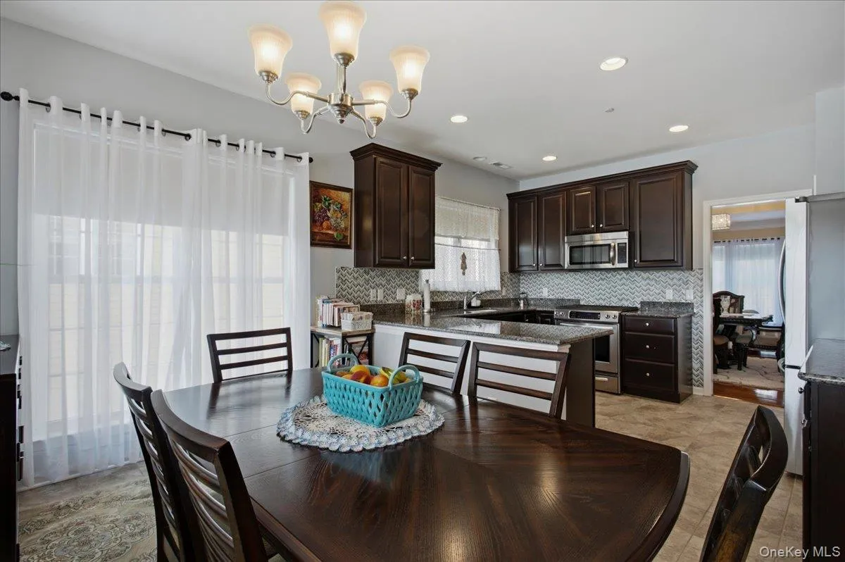Dining area opening into a kitchen featuring recessed lighting and a chandelier Dining area opening into a kitchen featuring recessed lighting and a chandelier