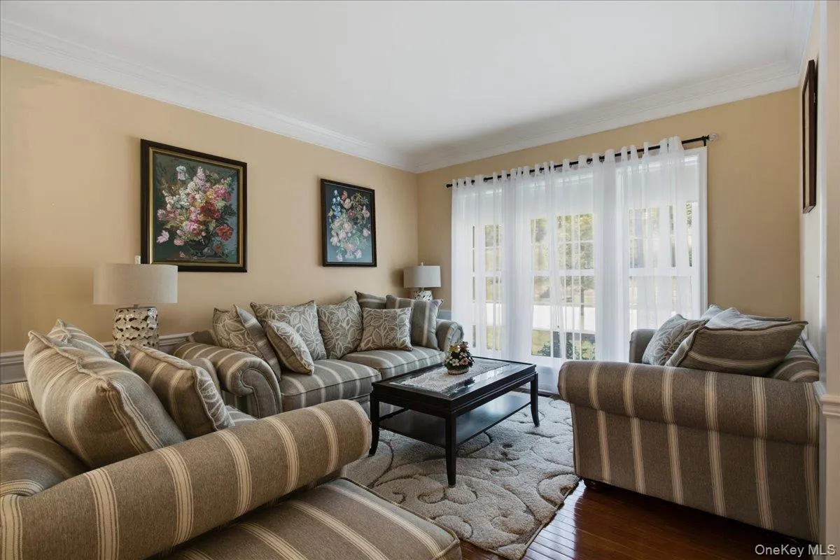 Living area featuring hardwood flooring and crown molding Living area featuring hardwood flooring and crown molding