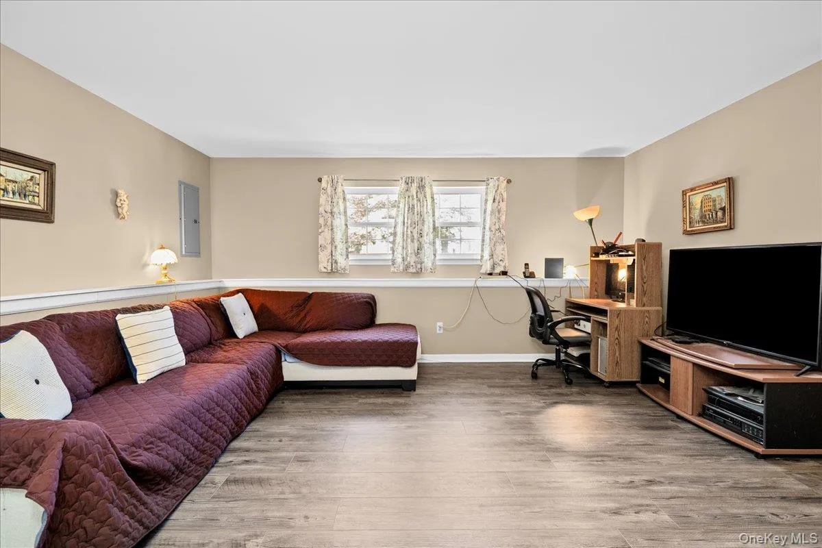 Nice spacious room featuring wood-finish flooring, neutral-toned walls, and white trim Nice spacious room featuring wood-finish flooring, neutral-toned walls, and white trim