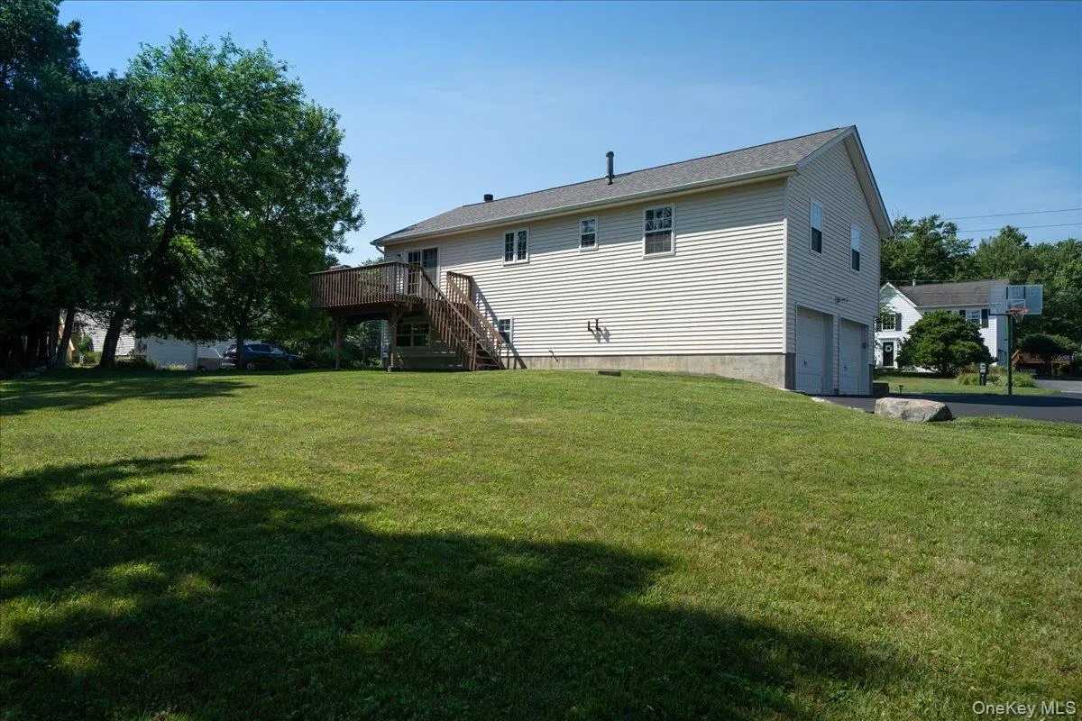 Expansive grassy green lawn with mature trees and a two-car garage Expansive grassy green lawn with mature trees and a two-car garage