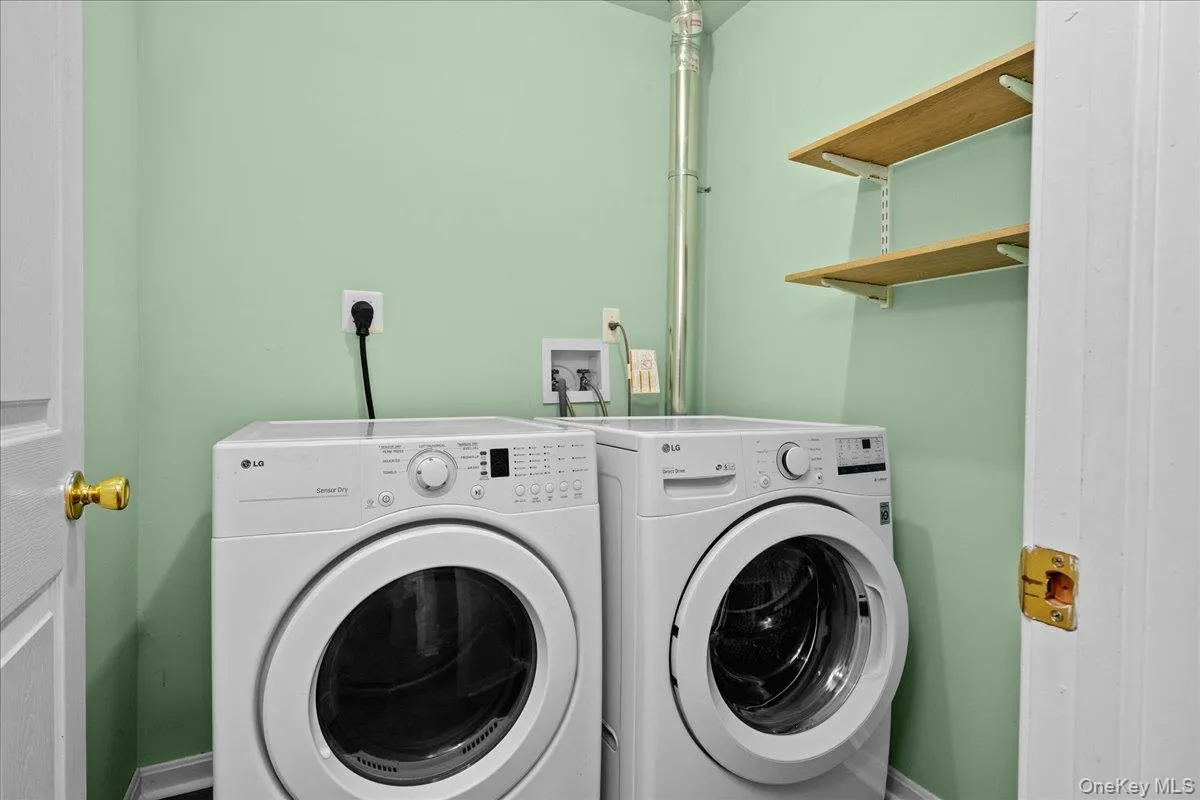 Laundry area featuring a front-loading washer and dryer set Laundry area featuring a front-loading washer and dryer set