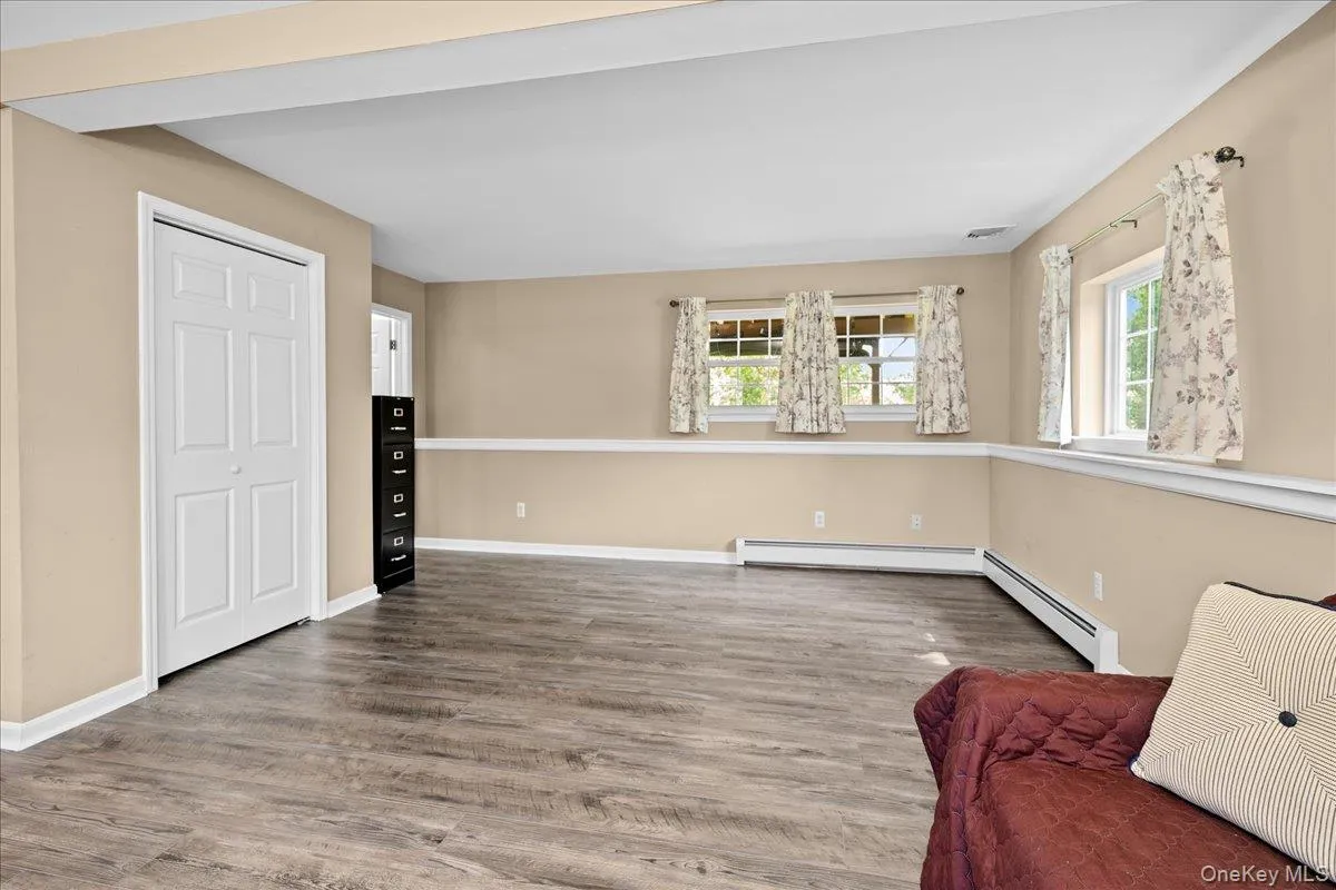 Nice spacious room featuring wood-finish flooring, neutral-toned walls, and white trim Nice spacious room featuring wood-finish flooring, neutral-toned walls, and white trim