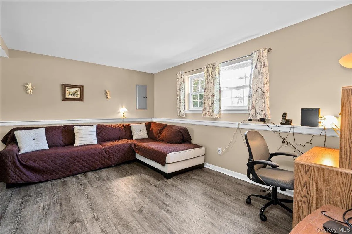 Bonus room featuring wood-finish flooring, two large windows, beige walls with white trim, and a white ceiling Bonus room featuring wood-finish flooring, two large windows, beige walls with white trim, and a white ceiling