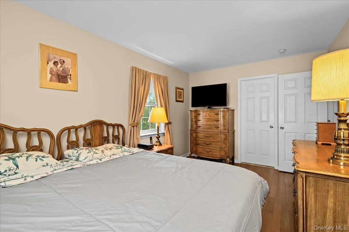 Bedroom 1 featuring wood-finish flooring, neutral wall tones, and white trim Bedroom 1 featuring wood-finish flooring, neutral wall tones, and white trim