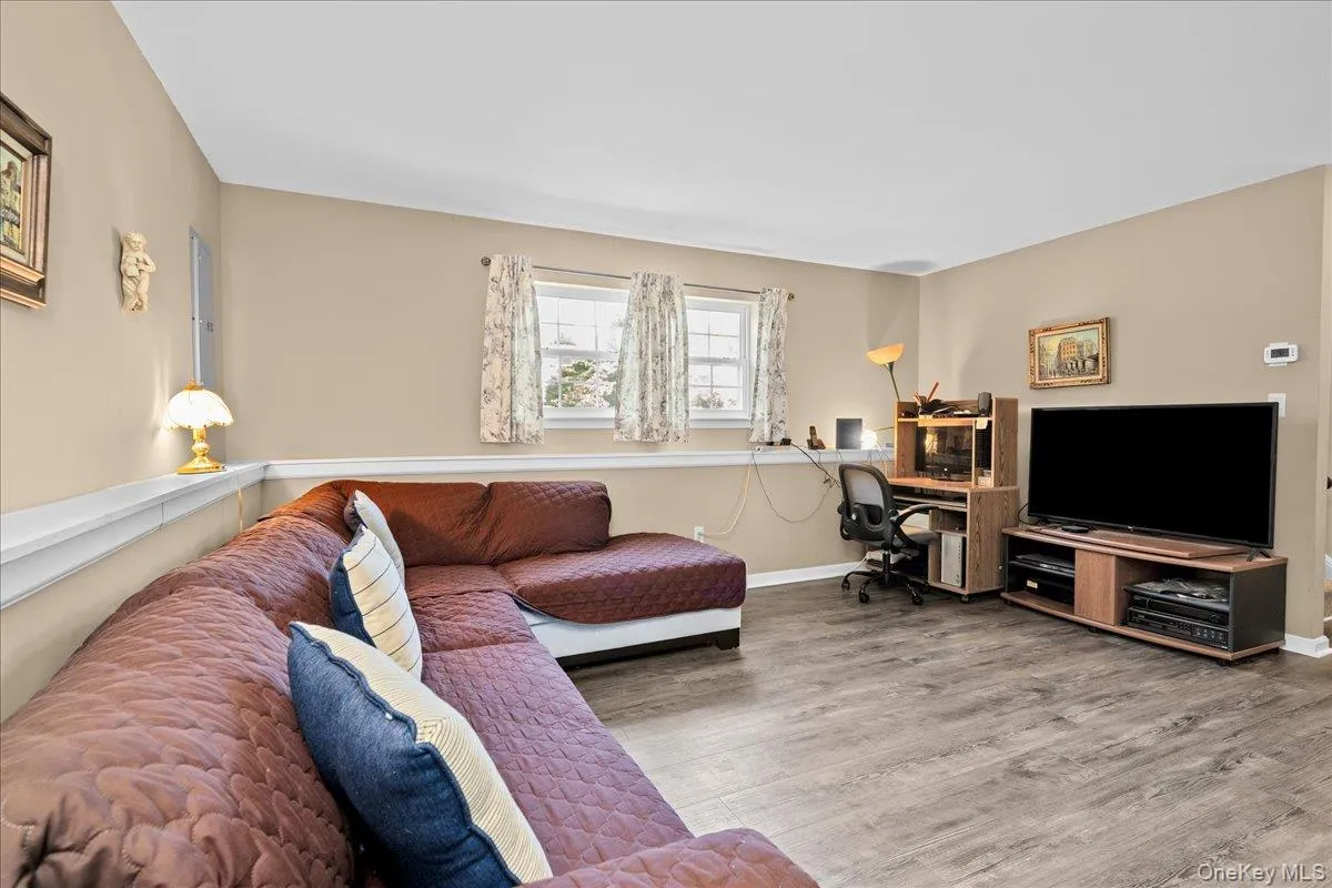 Nice spacious room featuring wood-finish flooring, neutral-toned walls, and white trim Nice spacious room featuring wood-finish flooring, neutral-toned walls, and white trim