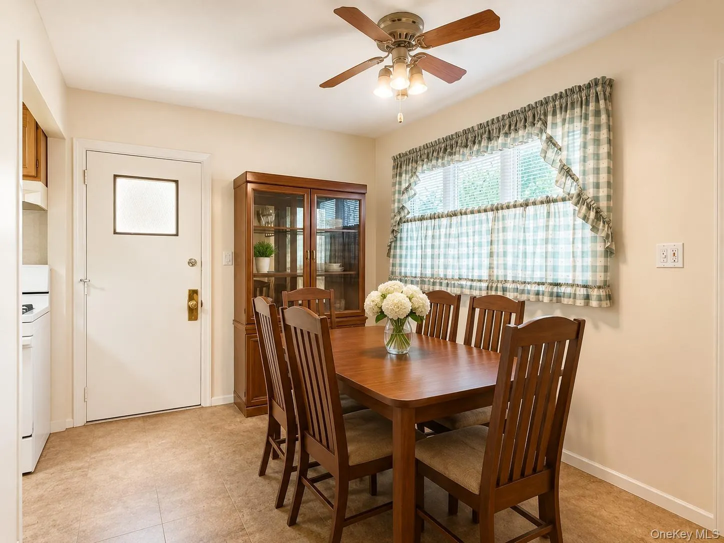 Dining area featuring a ceiling fan with integrated lighting, a window with blinds, and vinyl flooring Dining area featuring a ceiling fan with integrated lighting, a window with blinds, and vinyl flooring