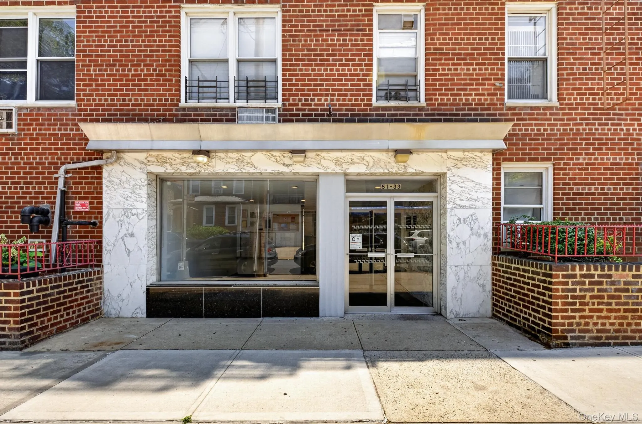 Red brick facade featuring a ground-level storefront with large display windows Red brick facade featuring a ground-level storefront with large display windows