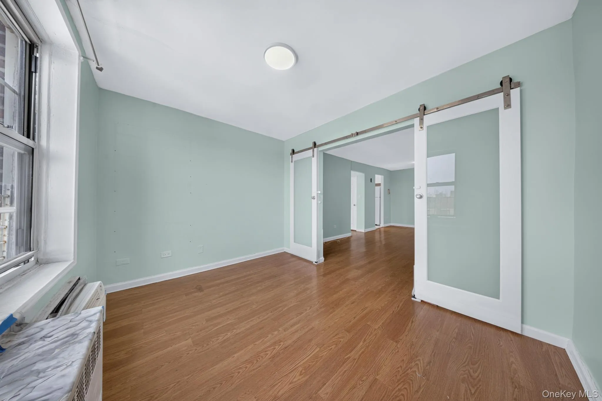 Room with wood-finish flooring and light blue walls Room with wood-finish flooring and light blue walls
