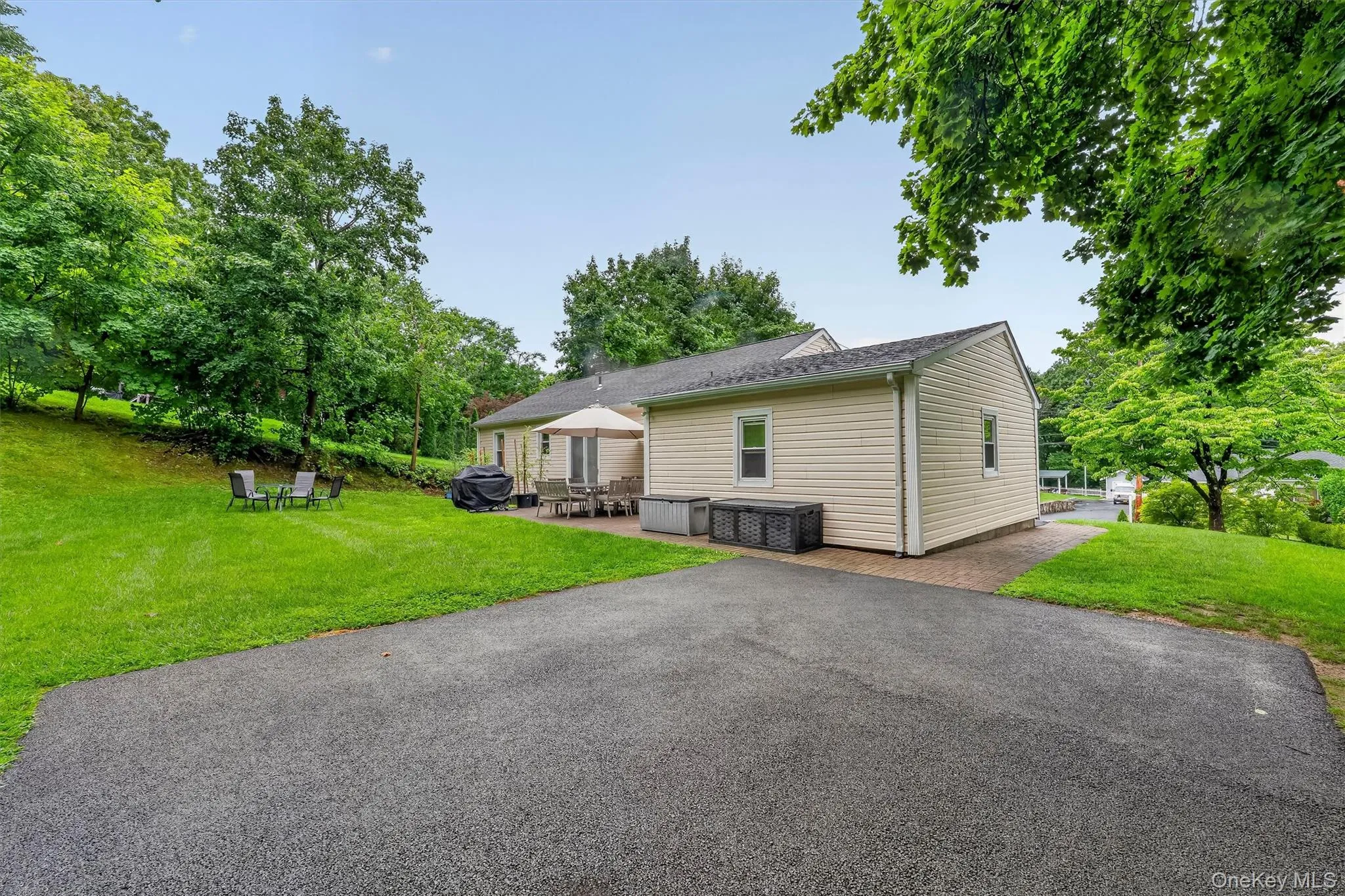Private backyard features a spacious paved area offering plenty of flexibility for a basketball court, recreation area, or other outdoor activities. Private backyard features a spacious paved area offering plenty of flexibility for a basketball court, recreation area, or other outdoor activities.