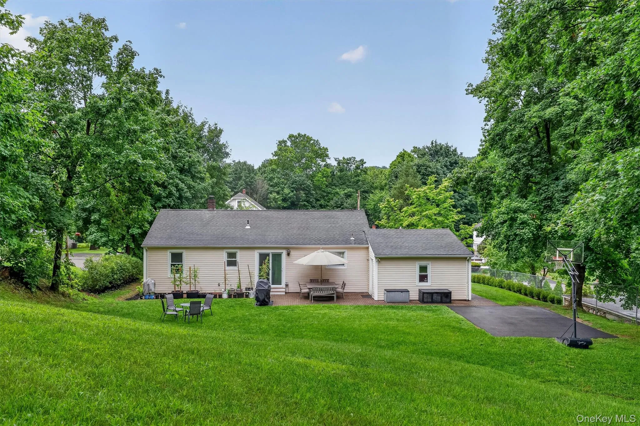 Private backyard features a spacious paved area offering plenty of flexibility for a basketball court, recreation area, or other outdoor activities. Private backyard features a spacious paved area offering plenty of flexibility for a basketball court, recreation area, or other outdoor activities.