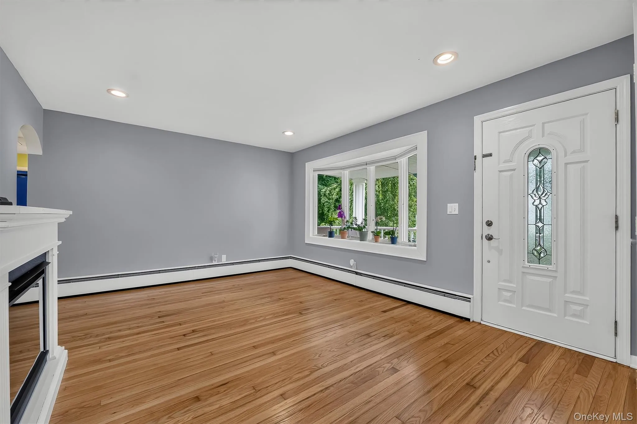 Sun-filled living room featuring beautifully refinished hardwood floors and a lovely bay window. Sun-filled living room featuring beautifully refinished hardwood floors and a lovely bay window.