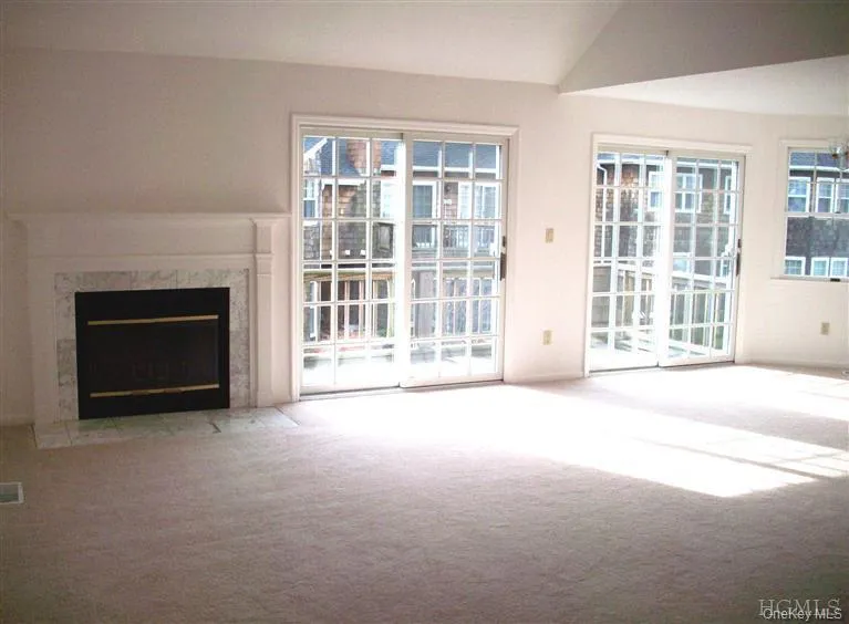 Open concept living room with fireplace and 2 sliding glass doors to balcony. Open concept living room with fireplace and 2 sliding glass doors to balcony.