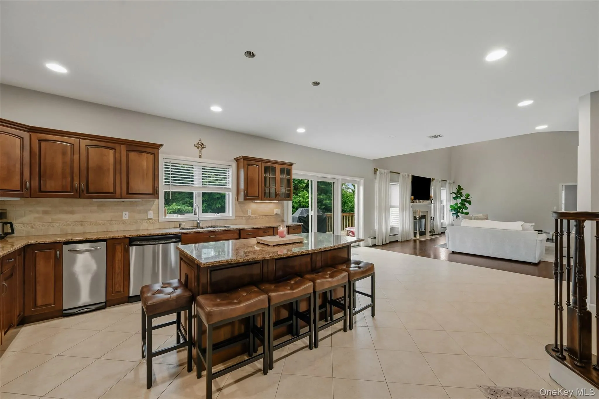 Kitchen featuring wood cabinetry, stainless steel appliances, a center island with a granite countertop, and recessed lighting Kitchen featuring wood cabinetry, stainless steel appliances, a center island with a granite countertop, and recessed lighting