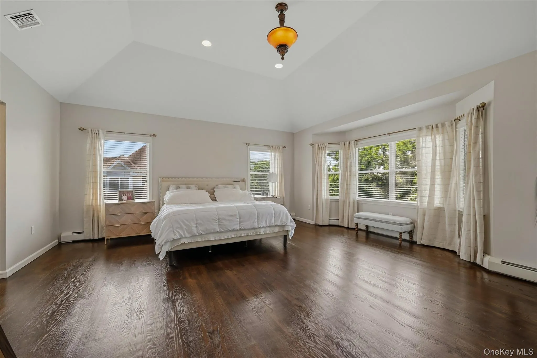 Spacious room featuring rich wood-finish flooring and a vaulted ceiling Spacious room featuring rich wood-finish flooring and a vaulted ceiling