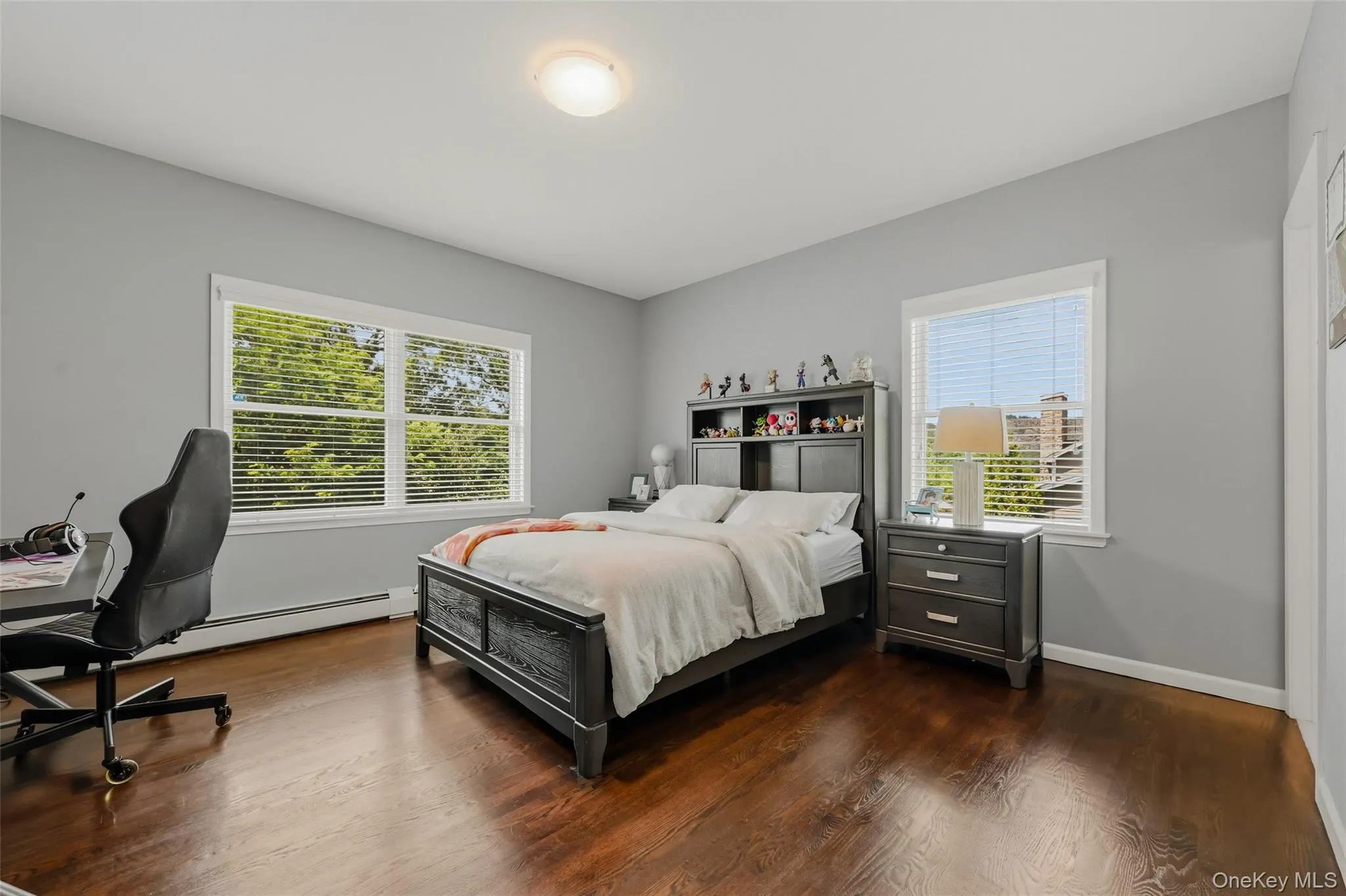 Bedroom featuring rich wood-finish flooring and light walls Bedroom featuring rich wood-finish flooring and light walls
