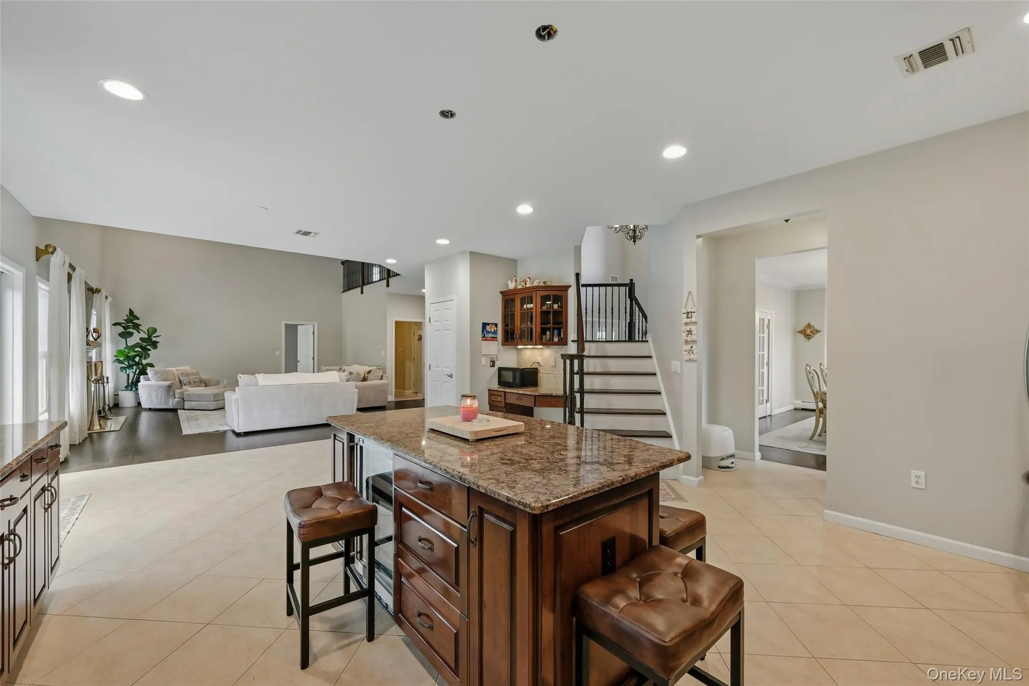 Kitchen island with granite countertop and integrated seating, featuring warm wood cabinetry Kitchen island with granite countertop and integrated seating, featuring warm wood cabinetry