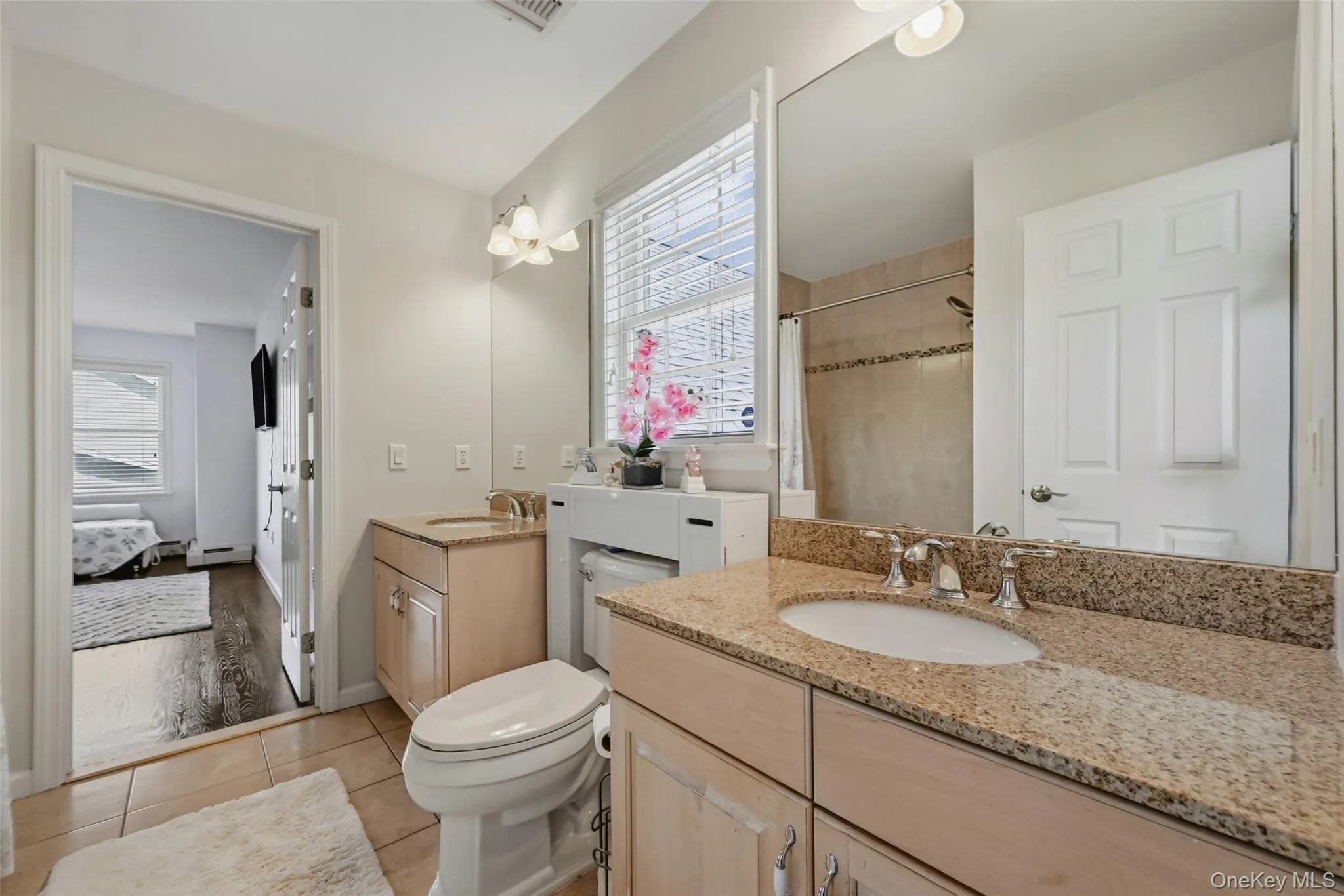 Jack and Jill Bathroom featuring dual vanity with light-toned wood cabinetry and undermount sinks Jack and Jill Bathroom featuring dual vanity with light-toned wood cabinetry and undermount sinks