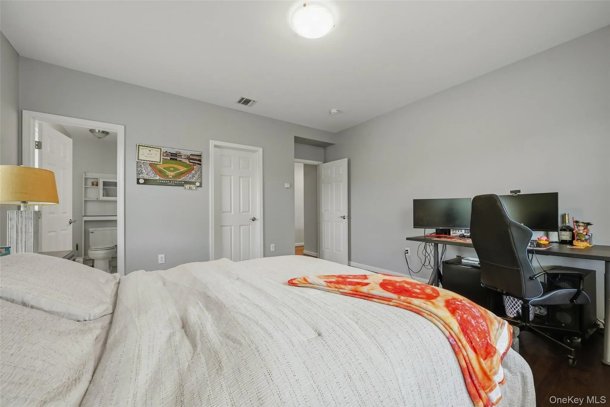 Spacious room featuring dark wood-finish flooring and a neutral color palette Spacious room featuring dark wood-finish flooring and a neutral color palette