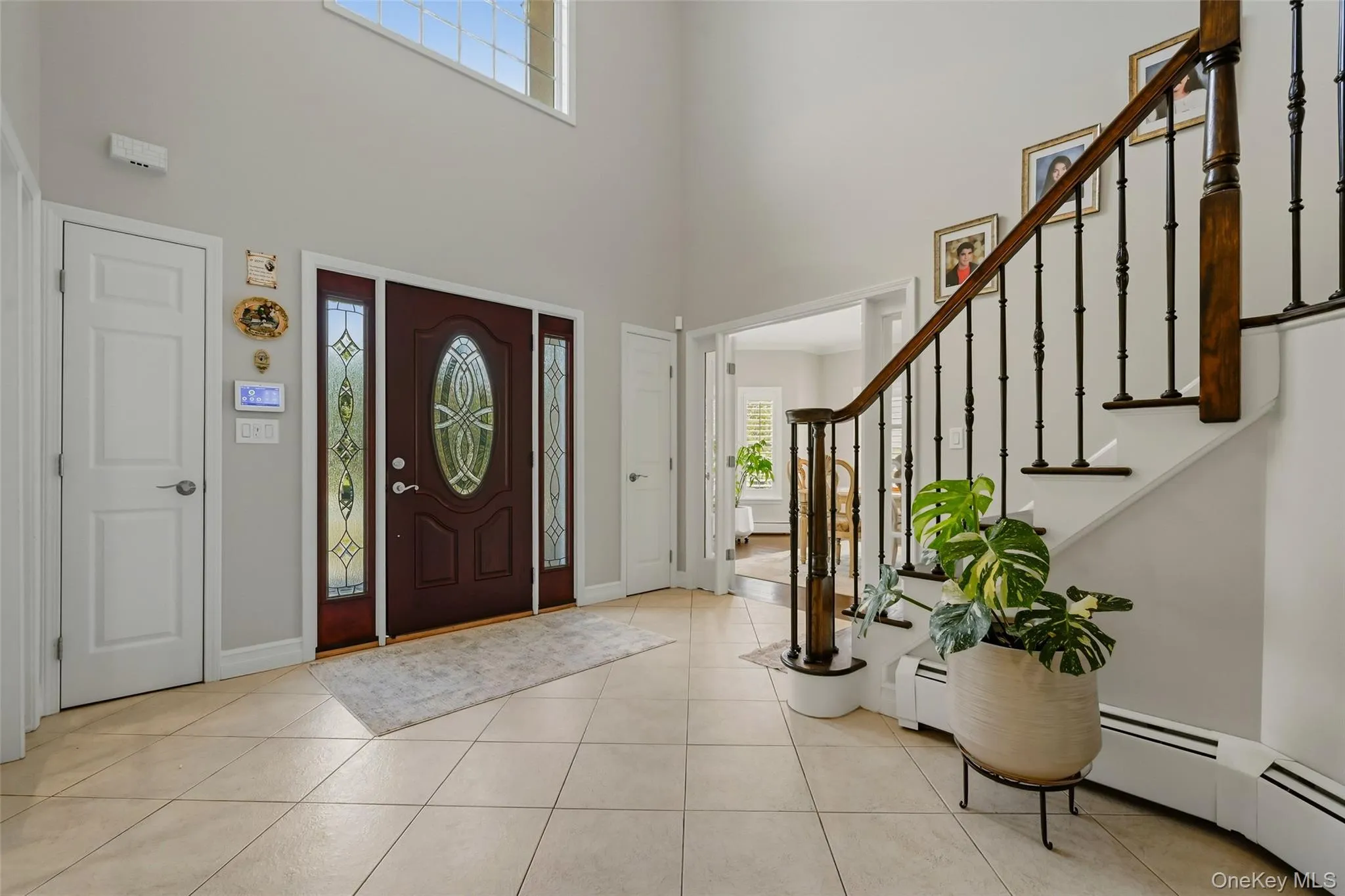 Two-story foyer featuring a dark wood entry door with decorative glass, side lights, and transom window Two-story foyer featuring a dark wood entry door with decorative glass, side lights, and transom window