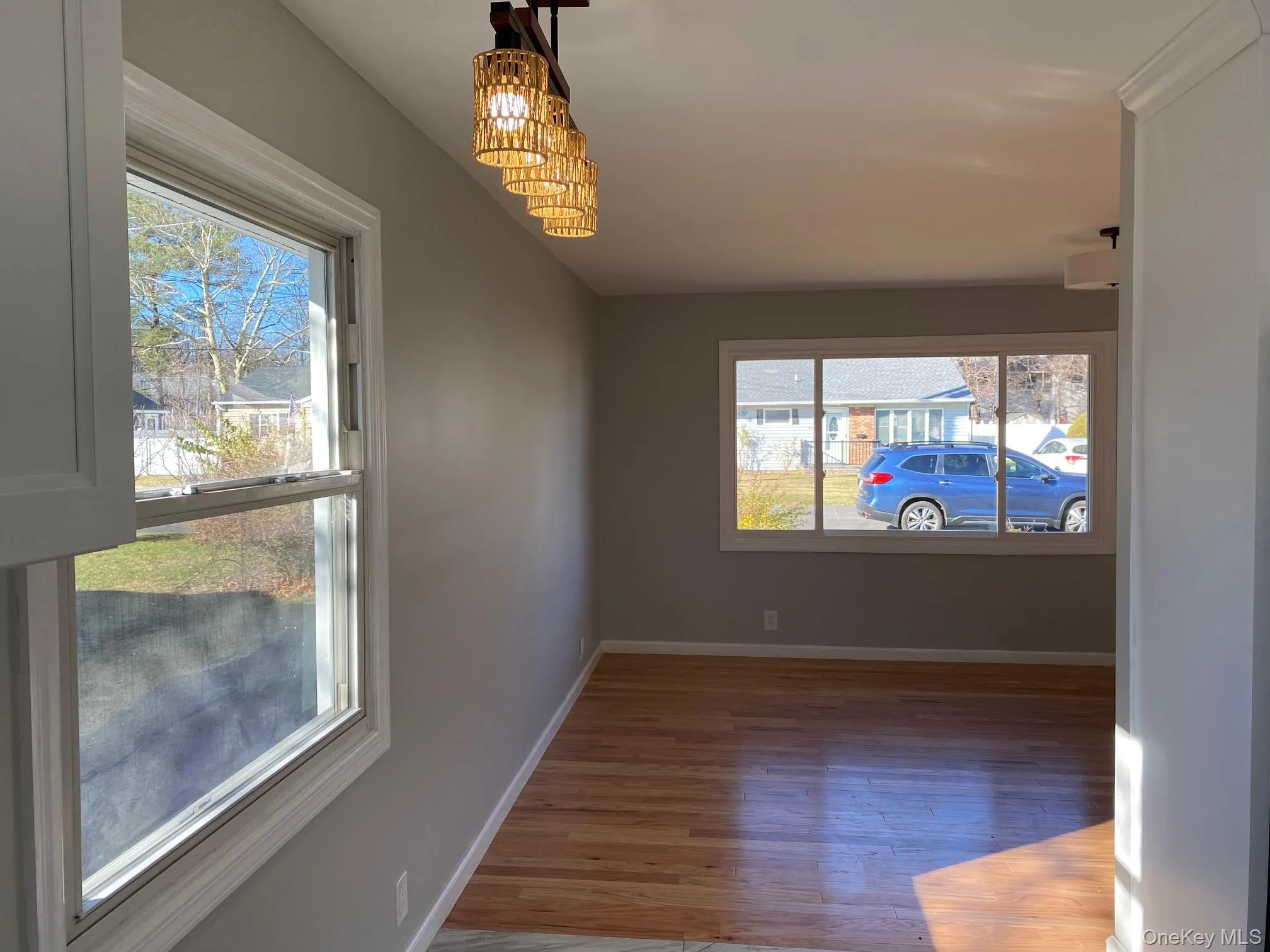 Empty room with light wood finished floors and baseboards Empty room with light wood finished floors and baseboards