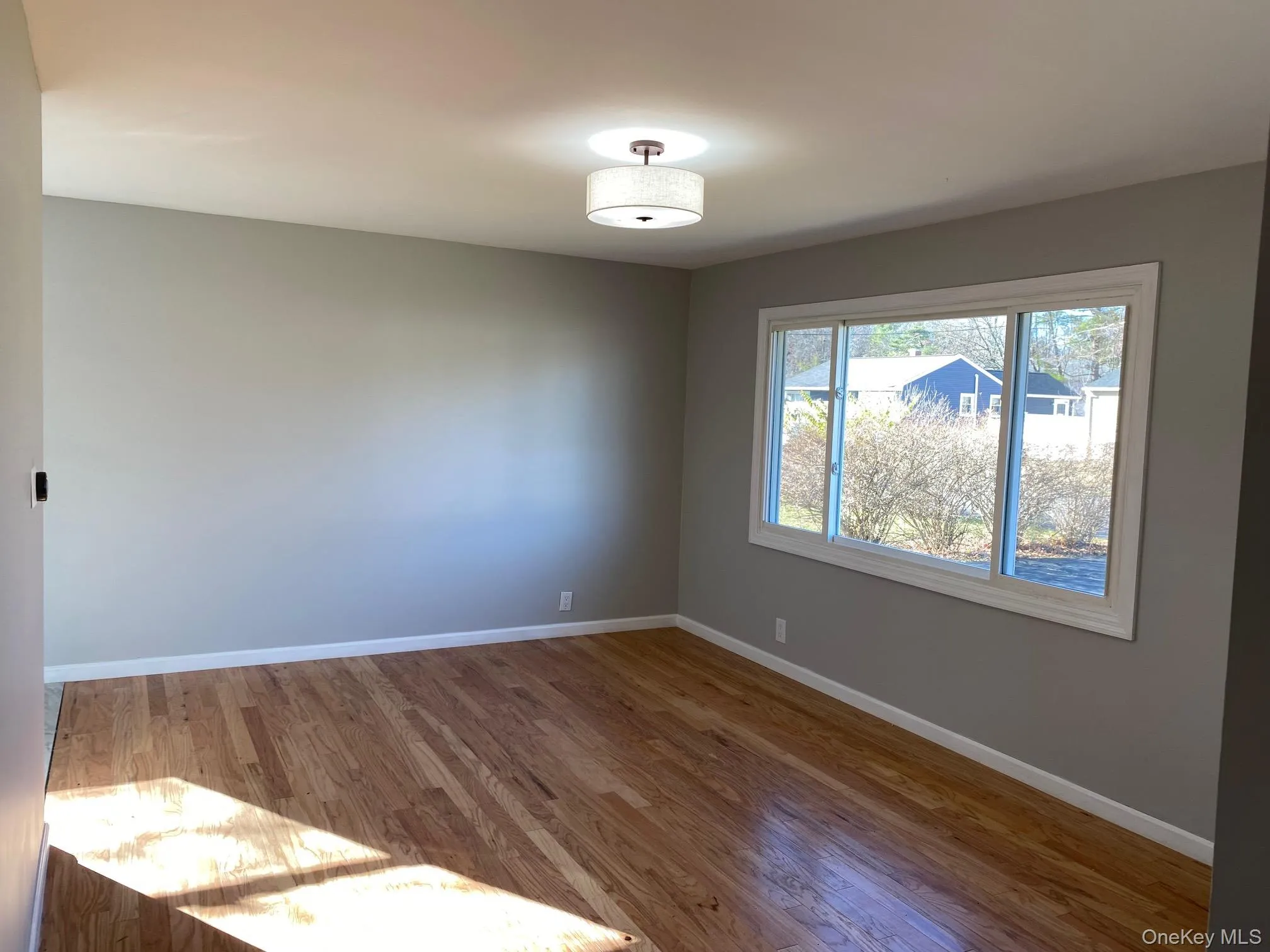 Empty room with baseboards and wood finished floors Empty room with baseboards and wood finished floors