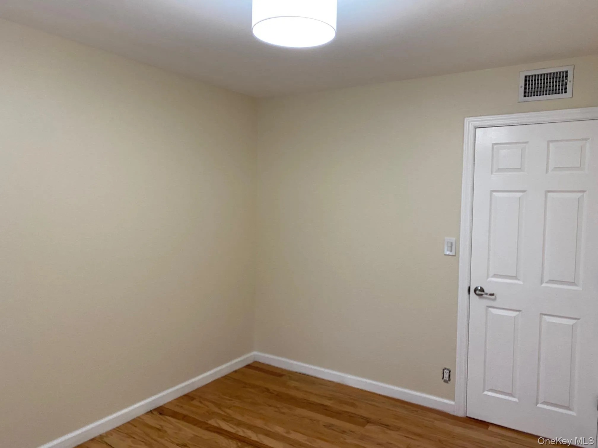 Bedroom 1 - with light hardwood floors and baseboards Bedroom 1 - with light hardwood floors and baseboards