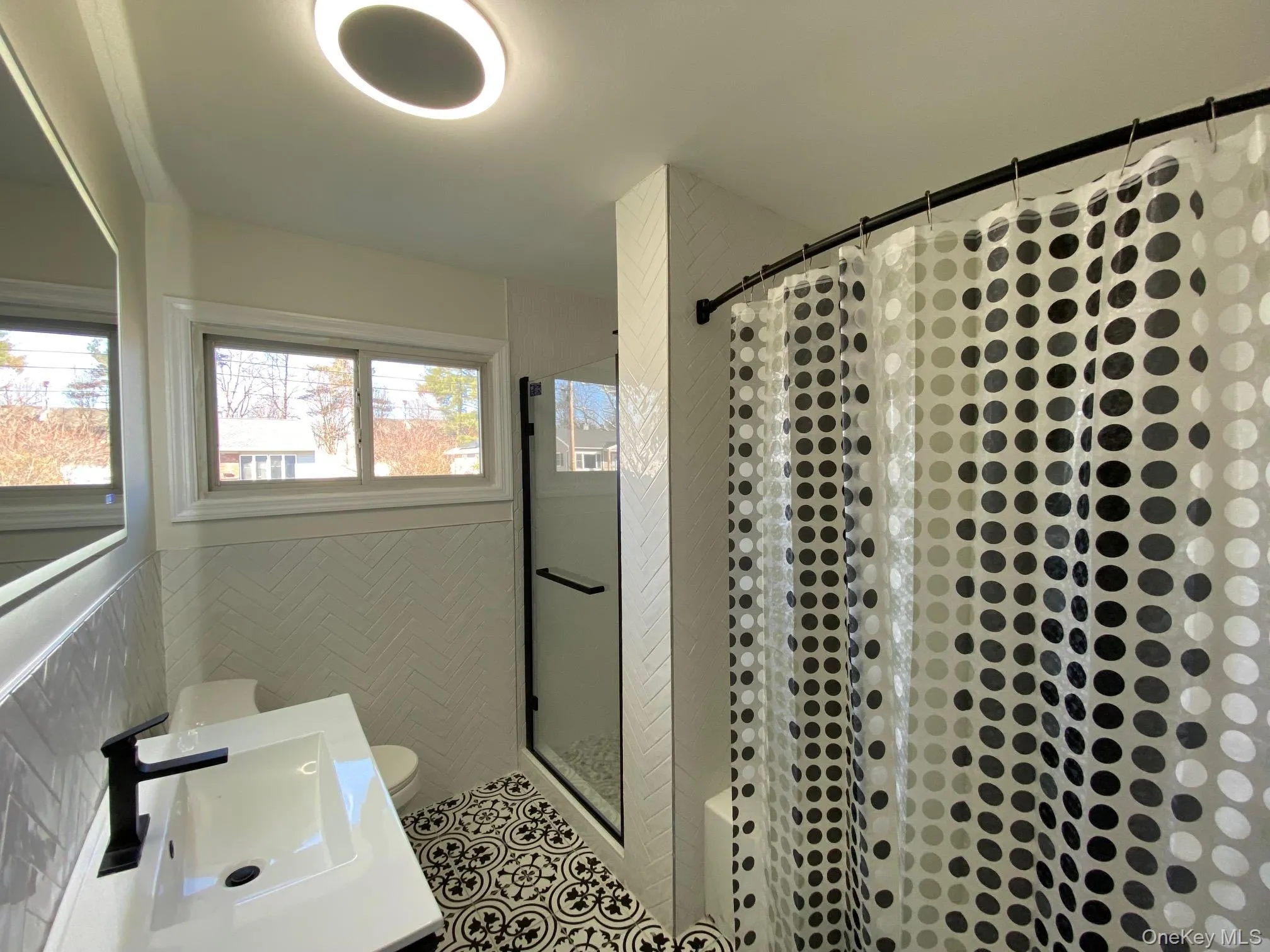 Full bath with a stall shower, vanity, and wainscoting Full bath with a stall shower, vanity, and wainscoting