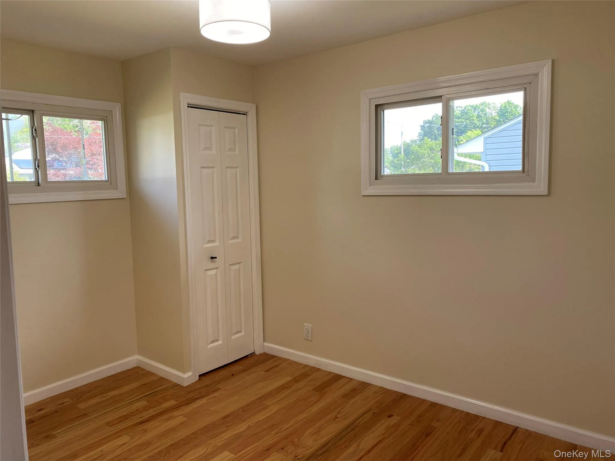 Bedroom 3 - Unfurnished bedroom with light wood-type flooring, a closet, and multiple windows Bedroom 3 - Unfurnished bedroom with light wood-type flooring, a closet, and multiple windows