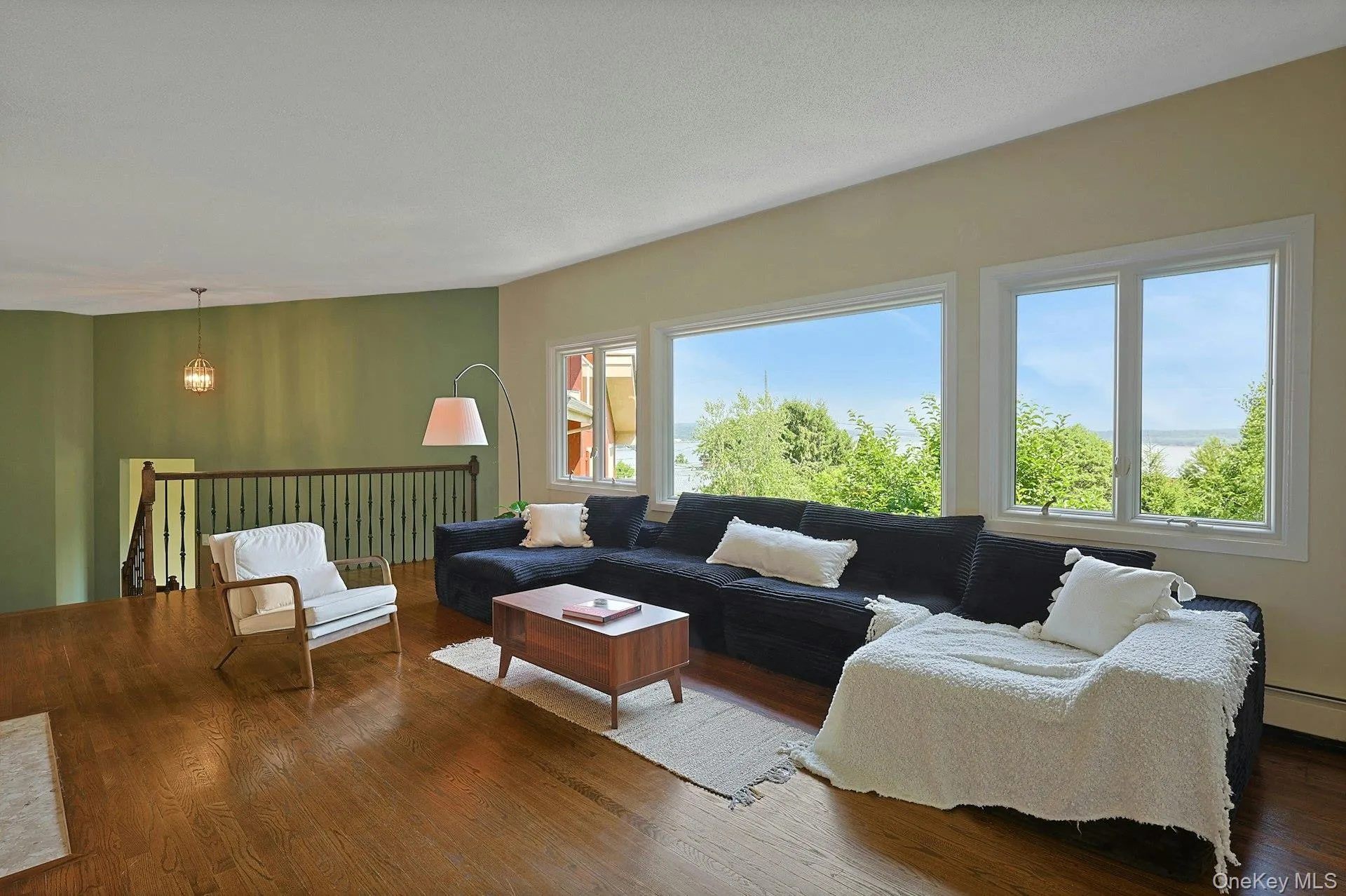 The expansive living room features large windows with views out to the beautiful front lawn and river beyond. The expansive living room features large windows with views out to the beautiful front lawn and river beyond.