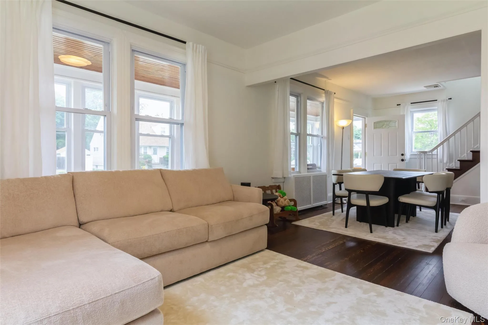 Living area featuring dark wood flooring and white walls Living area featuring dark wood flooring and white walls