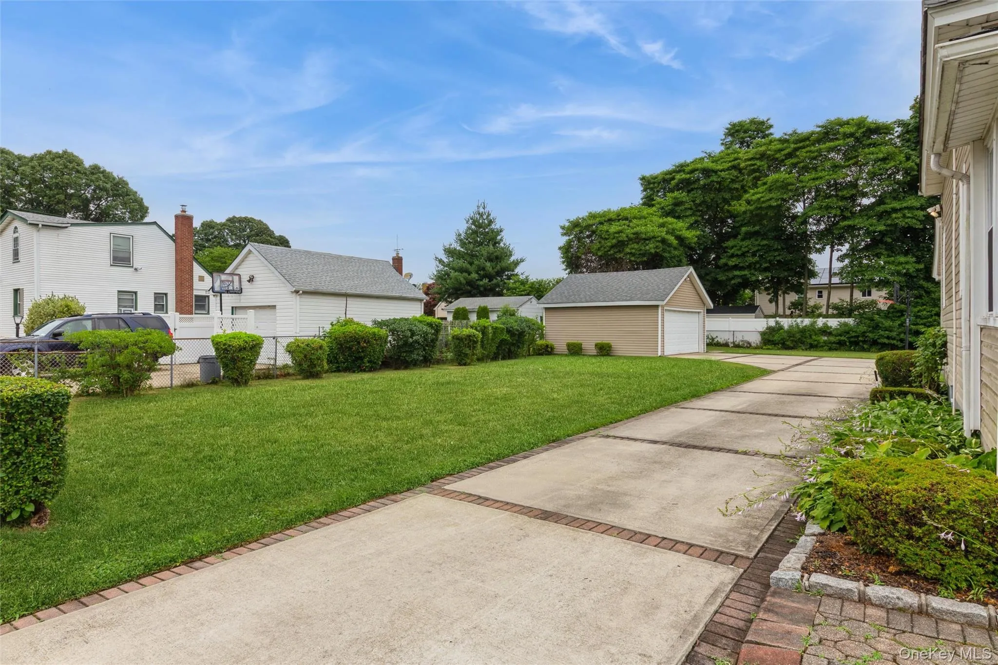 Expansive concrete driveway featuring brick accents Expansive concrete driveway featuring brick accents