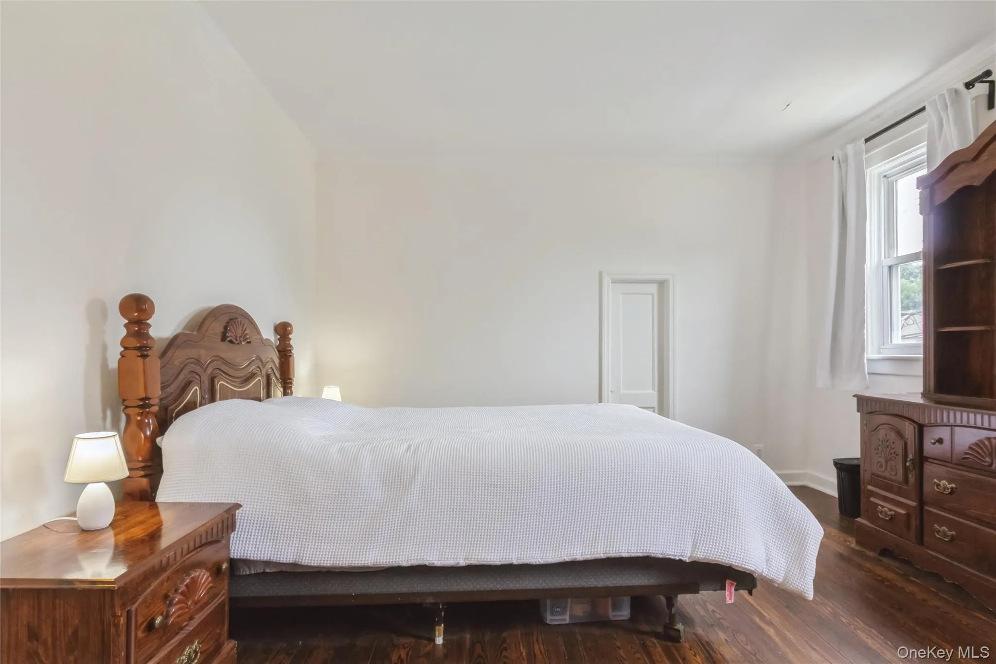 Bright room featuring wood-finish flooring and a white color palette Bright room featuring wood-finish flooring and a white color palette