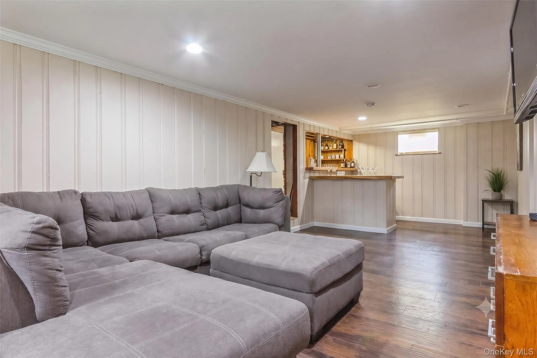 Recreational area featuring wood-finish flooring, paneled walls with crown molding, and recessed lighting Recreational area featuring wood-finish flooring, paneled walls with crown molding, and recessed lighting