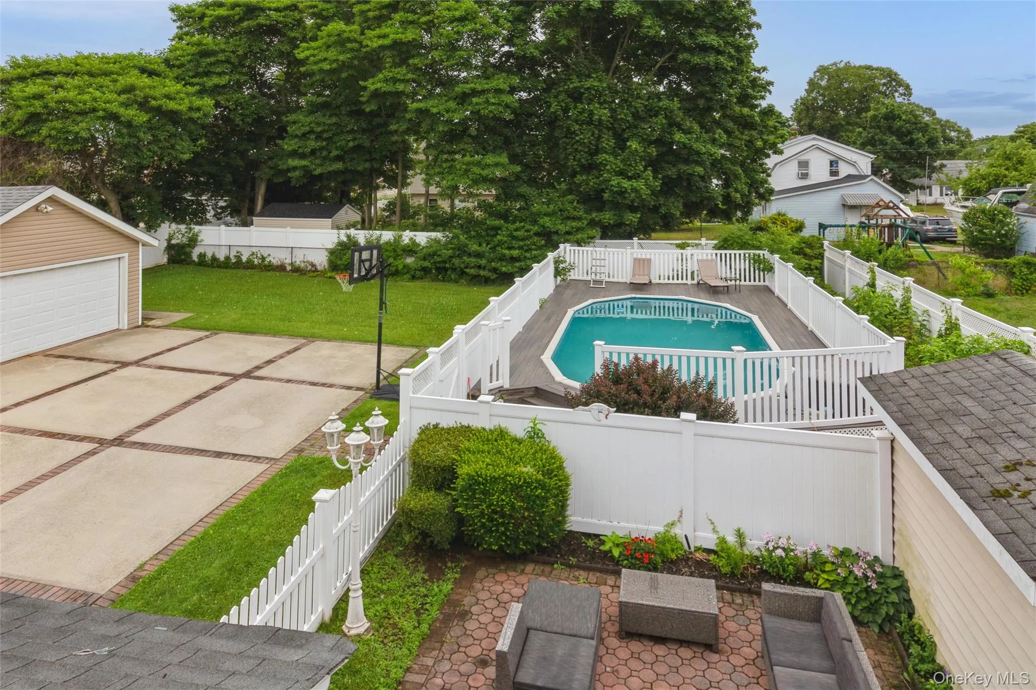 Backyard featuring swimming pool with a surrounding deck, a paved patio, and a separate garage structure Backyard featuring swimming pool with a surrounding deck, a paved patio, and a separate garage structure
