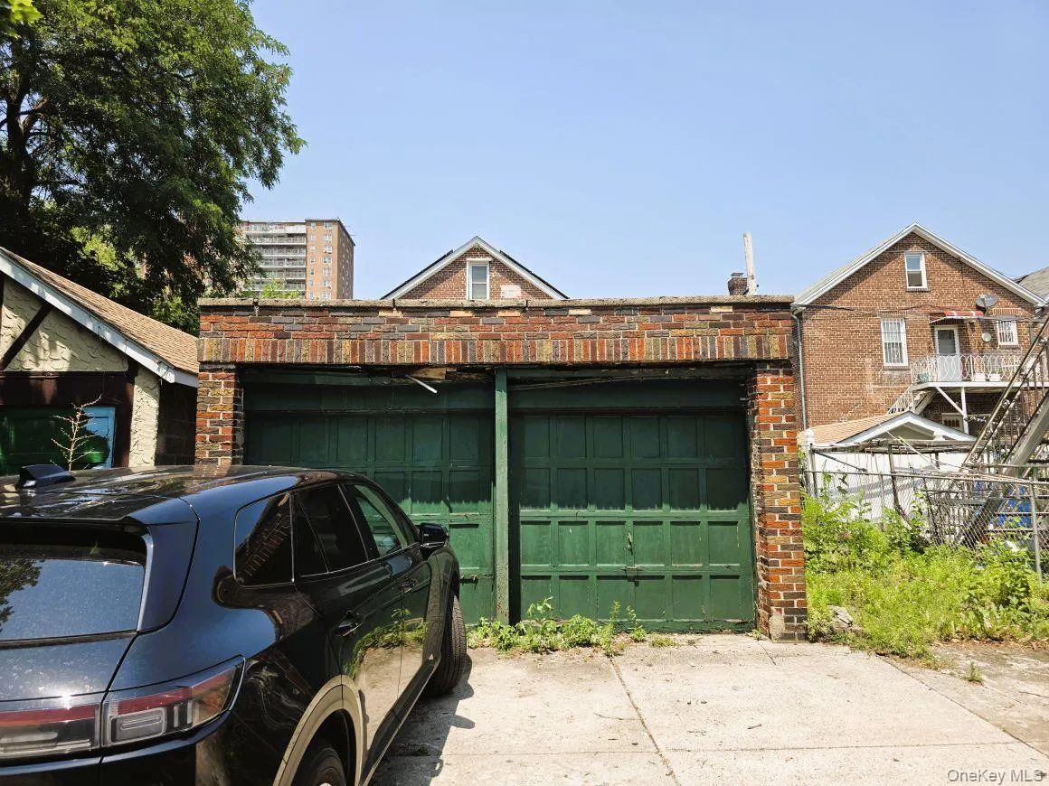 Brick two-car garage with green garage doors Brick two-car garage with green garage doors