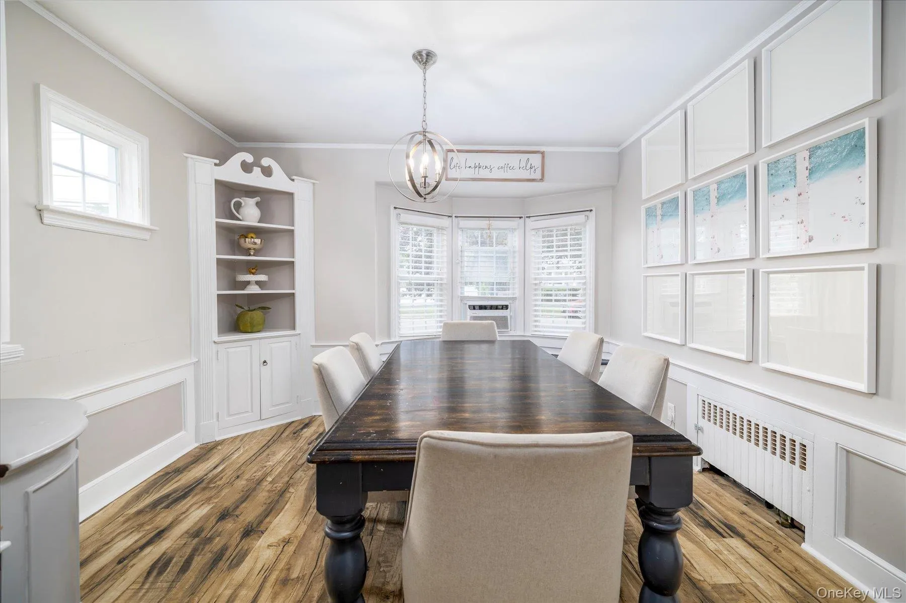 Dining space featuring wood-finish flooring, a built-in corner hutch and a bay window. Dining space featuring wood-finish flooring, a built-in corner hutch and a bay window.