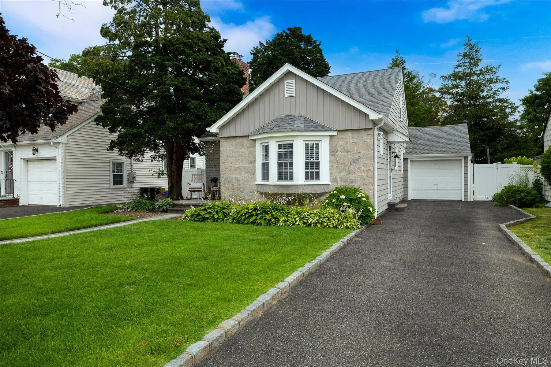 Stone and siding exterior with a prominent bay window, elongated driveway, 1 car garage Stone and siding exterior with a prominent bay window, elongated driveway, 1 car garage