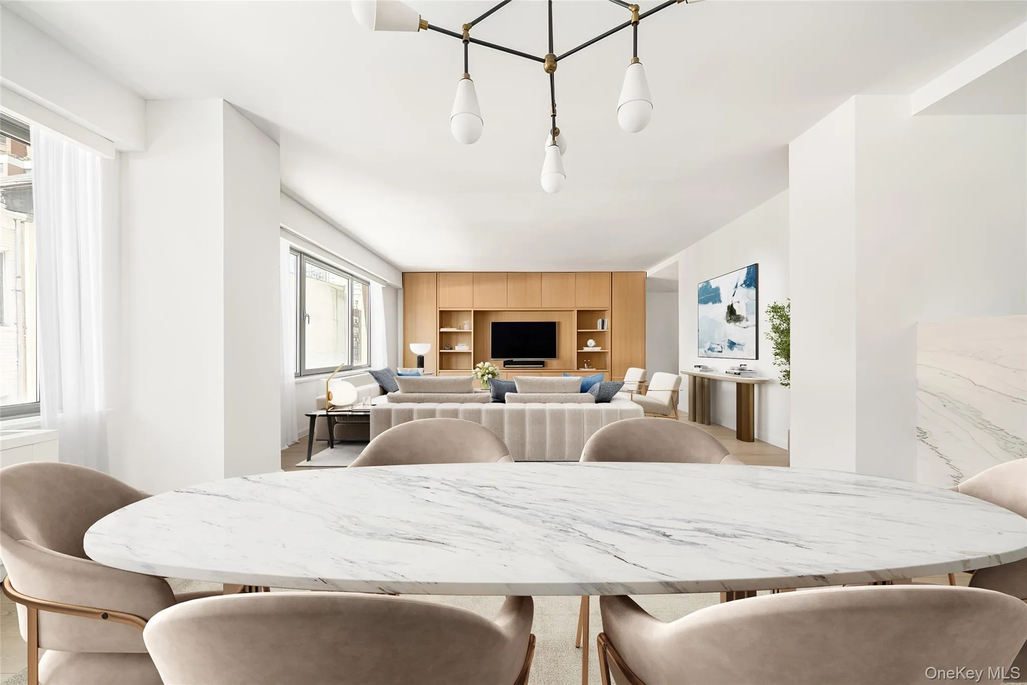 Open-concept interior featuring light wood-finish flooring and a central chandelier Open-concept interior featuring light wood-finish flooring and a central chandelier